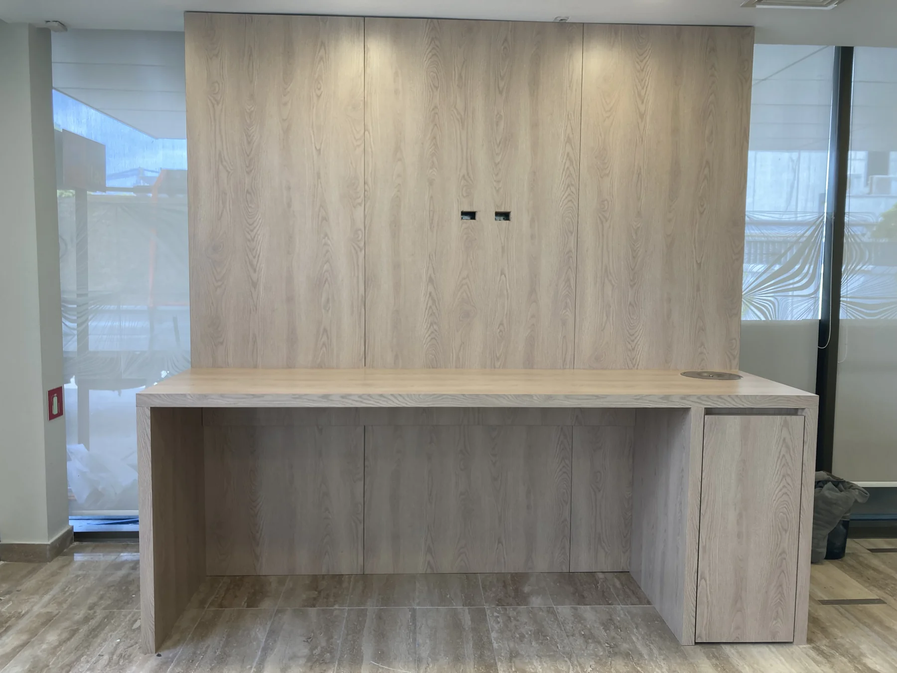 Mobiliario corporativo a medida con terminación en madera y espacio de almacenamiento